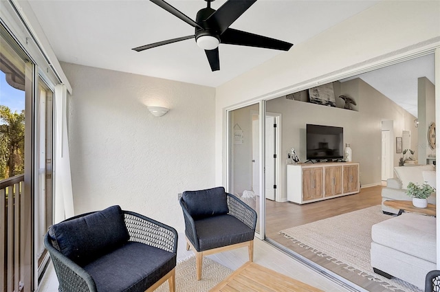 living room with ceiling fan, wood-type flooring, and vaulted ceiling