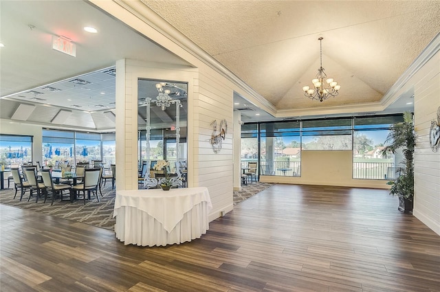 foyer entrance with floor to ceiling windows, an inviting chandelier, dark hardwood / wood-style floors, wood walls, and ornamental molding