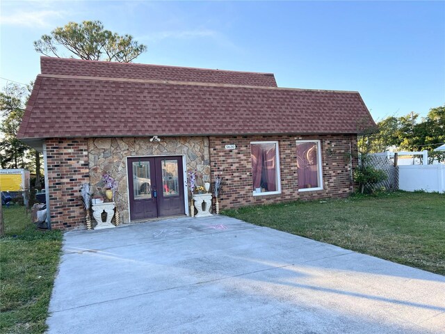 view of front of property with french doors and a front lawn