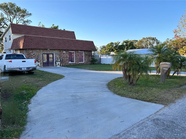 view of front facade with french doors and a front lawn