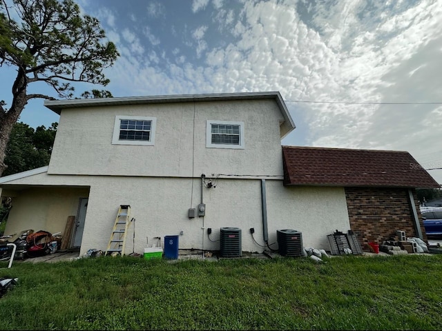 5630 3rd St W, Bradenton, FL 34207 - back of house featuring stucco siding, a yard, and a shingled roof
