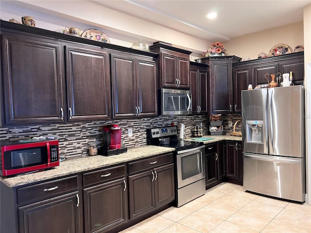 5630 3rd St W, Bradenton, FL 34207 - kitchen with stainless steel appliances, light tile patterned floors, backsplash, light stone countertops, and dark brown cabinets
