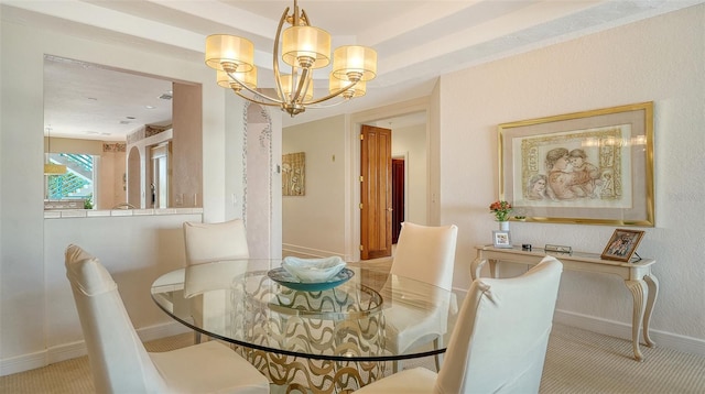 carpeted dining room featuring a chandelier