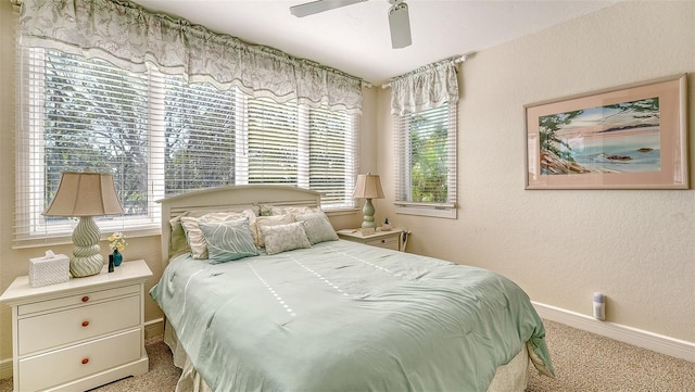 bedroom with multiple windows, light carpet, and ceiling fan