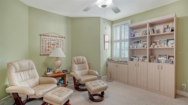 sitting room with ceiling fan and light colored carpet