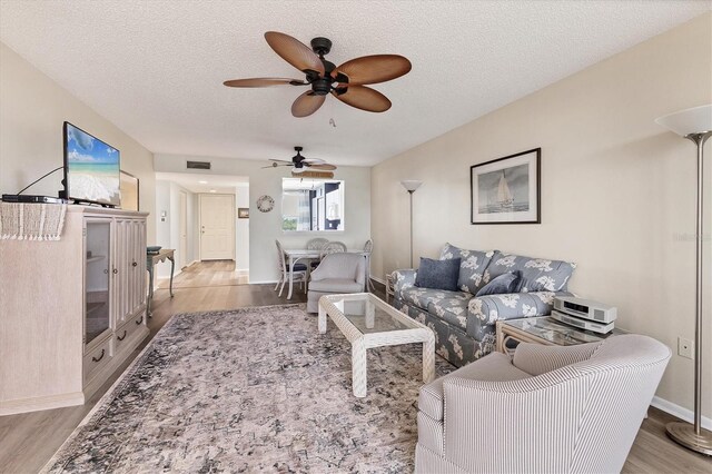 living room featuring a textured ceiling and light hardwood / wood-style flooring