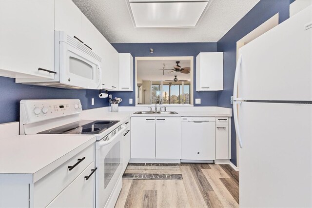 kitchen with a textured ceiling, white cabinetry, sink, and white appliances