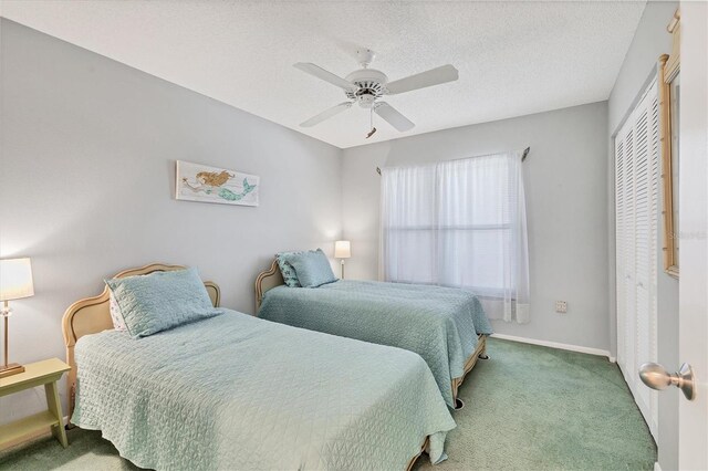 bedroom with carpet flooring, ceiling fan, a textured ceiling, and a closet