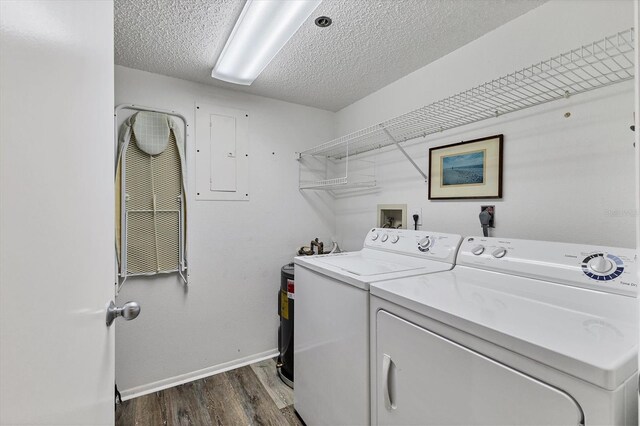 laundry room with electric panel, washer and clothes dryer, dark wood-type flooring, and a textured ceiling