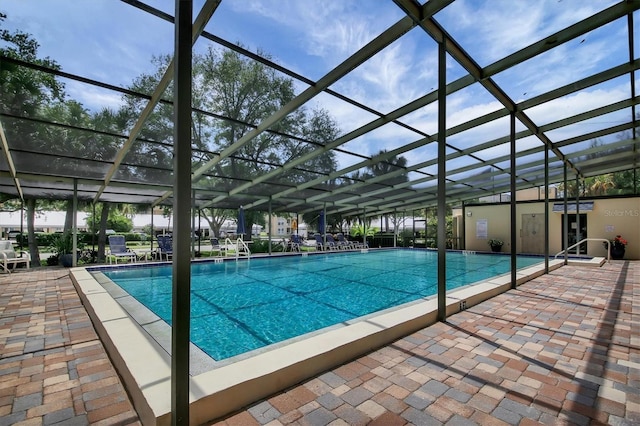 community pool with glass enclosure and a patio