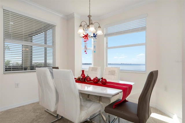 dining room with a water view, ornamental molding, light tile patterned floors, and a chandelier