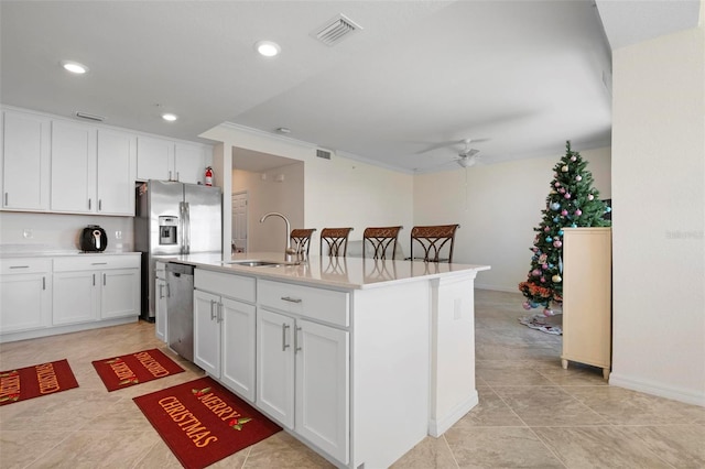 kitchen with sink, ceiling fan, an island with sink, white cabinetry, and stainless steel appliances