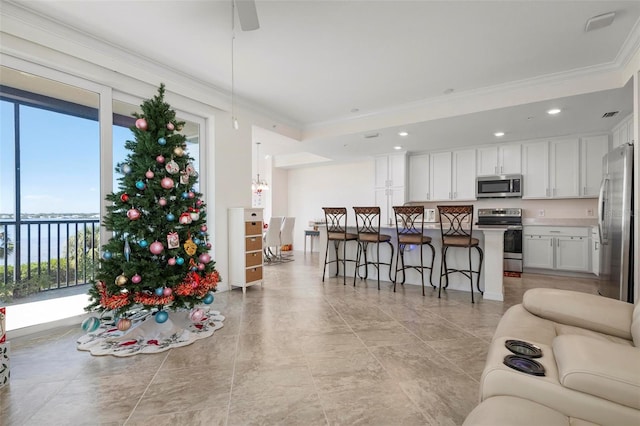 living room featuring a wealth of natural light, crown molding, and ceiling fan