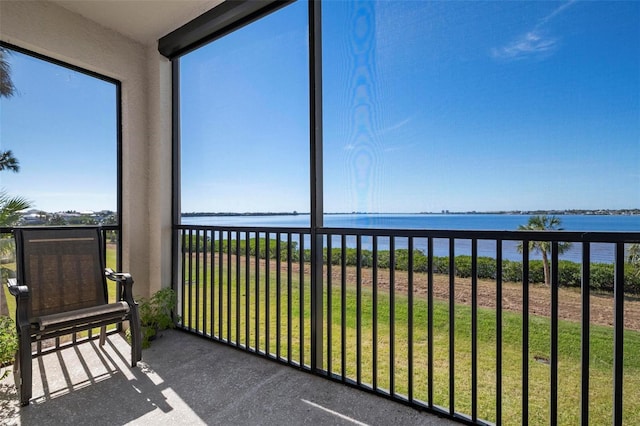 sunroom featuring a water view