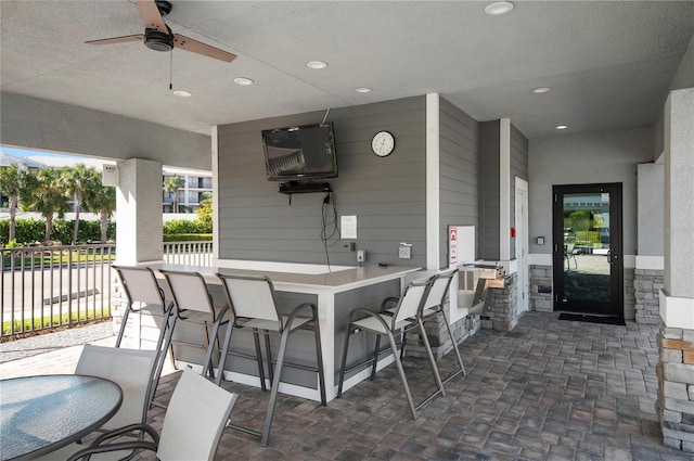 view of patio / terrace with ceiling fan and a bar