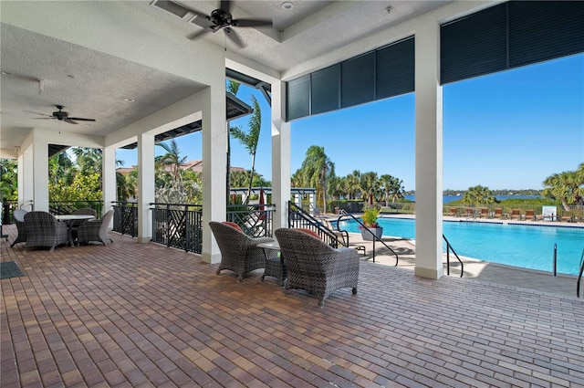 view of patio featuring ceiling fan and a community pool