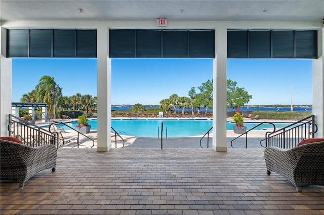 view of swimming pool featuring a patio area and a water view