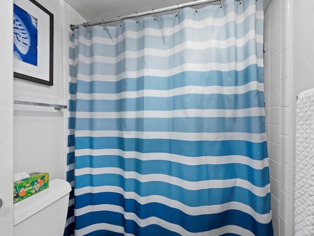 bathroom featuring a shower with shower curtain and toilet