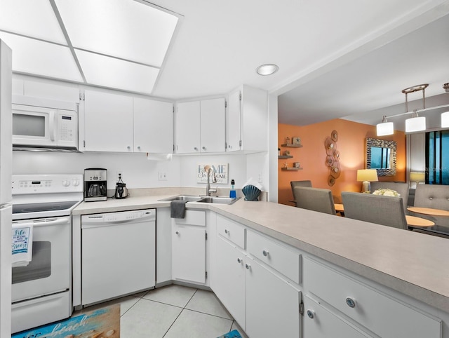 kitchen with white appliances, sink, light tile patterned floors, pendant lighting, and white cabinetry