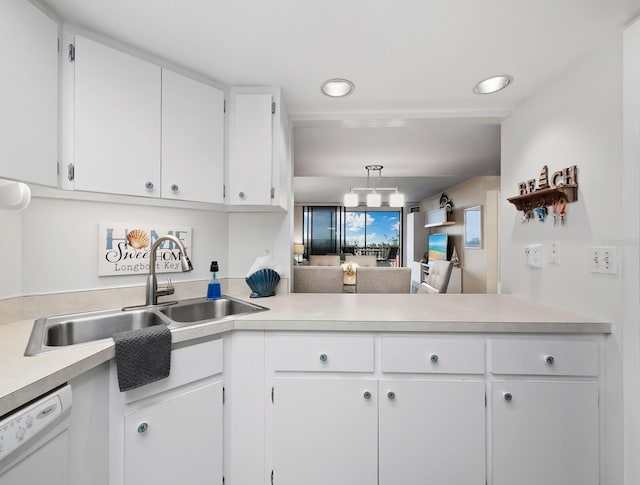 kitchen featuring white cabinets, white dishwasher, kitchen peninsula, and sink