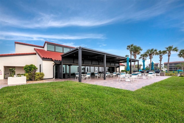 2045 Gulf Of Mexico Dr Unit M1-502, Longboat Key, FL 34228 - back of house with a patio area, a tiled roof, a yard, and stucco siding