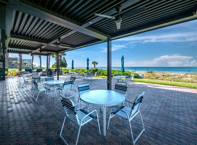 view of patio with ceiling fan and a water view