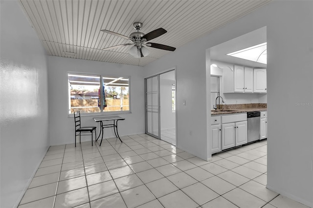 kitchen featuring ceiling fan, sink, white cabinets, and light tile patterned flooring