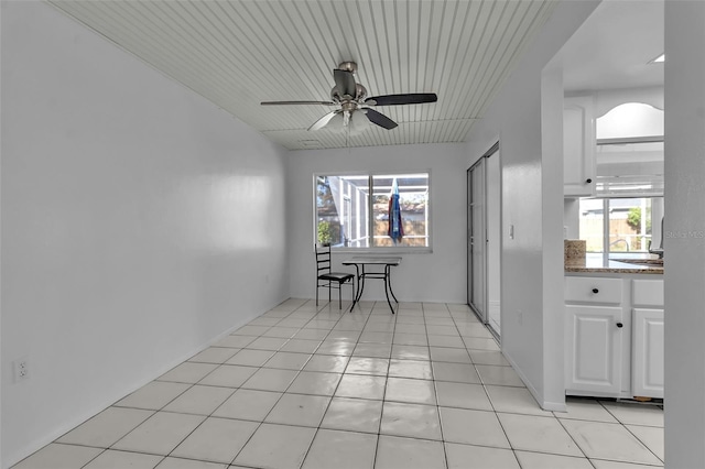 unfurnished dining area featuring plenty of natural light, ceiling fan, light tile patterned flooring, and wooden ceiling