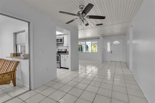 interior space featuring ceiling fan, wooden ceiling, and light tile patterned flooring