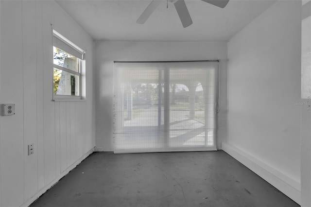 spare room featuring ceiling fan and concrete floors