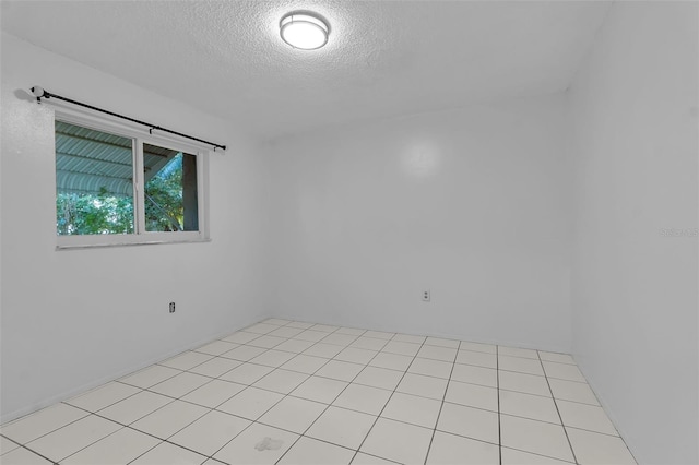 tiled spare room with a textured ceiling