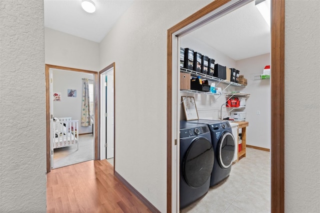 laundry area with wood-type flooring, a textured ceiling, and separate washer and dryer