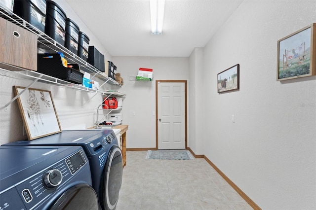 washroom with washing machine and clothes dryer and a textured ceiling