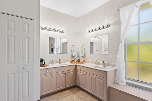 bathroom with tile patterned flooring, vanity, and a wealth of natural light