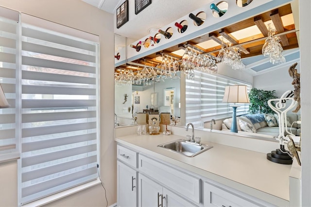 bar with white cabinets and sink