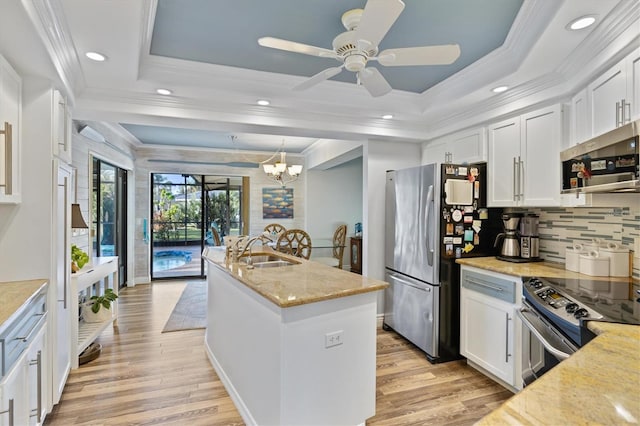 kitchen with sink, white cabinetry, stainless steel appliances, and a tray ceiling