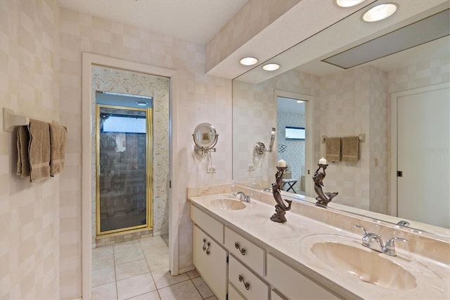 bathroom with tile patterned flooring, vanity, a shower with shower door, and tile walls