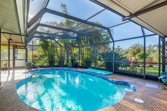 view of swimming pool with glass enclosure and a patio area