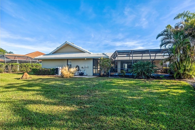 rear view of property featuring a yard, cooling unit, and a lanai