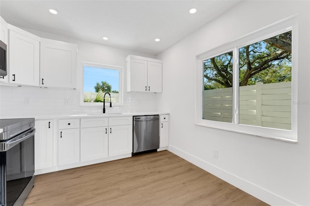 kitchen with white cabinets, plenty of natural light, sink, and appliances with stainless steel finishes