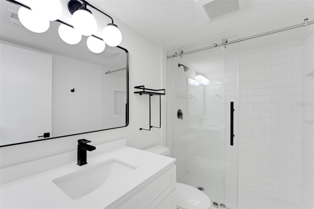 bathroom with vanity, toilet, and a shower with shower door