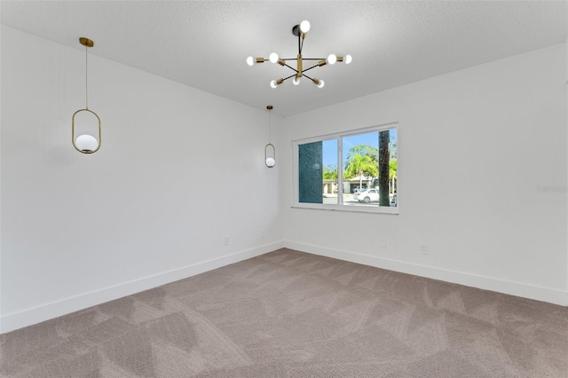 unfurnished room with carpet flooring, a textured ceiling, and a notable chandelier