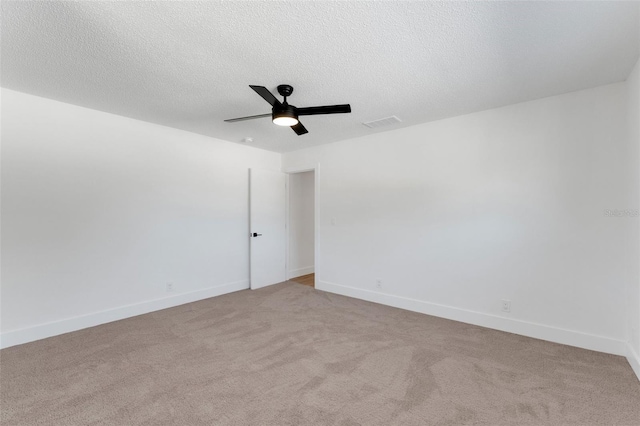 carpeted spare room with a textured ceiling and ceiling fan