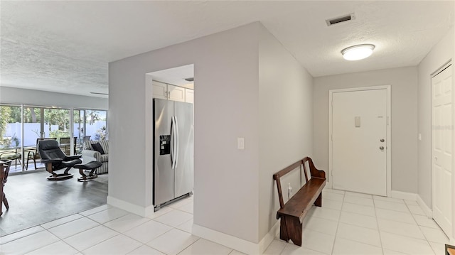 tiled entryway with a textured ceiling