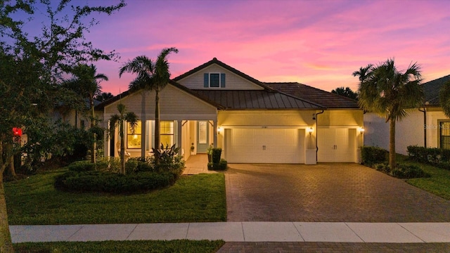 view of front of property with a garage and a yard