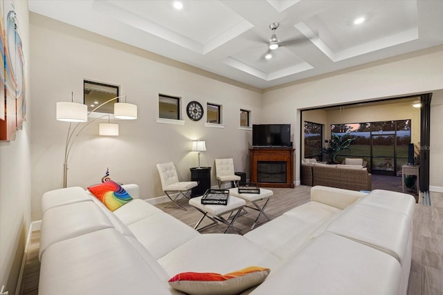 living room featuring beam ceiling, light wood-type flooring, ceiling fan, and coffered ceiling