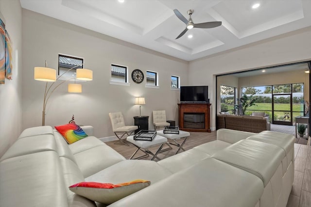 living room featuring beamed ceiling, ceiling fan, light hardwood / wood-style floors, and coffered ceiling