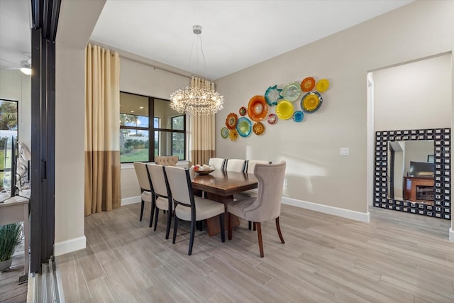 dining area featuring ceiling fan with notable chandelier and light hardwood / wood-style flooring