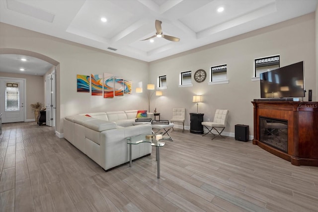 living room with beamed ceiling, light hardwood / wood-style flooring, ceiling fan, and coffered ceiling