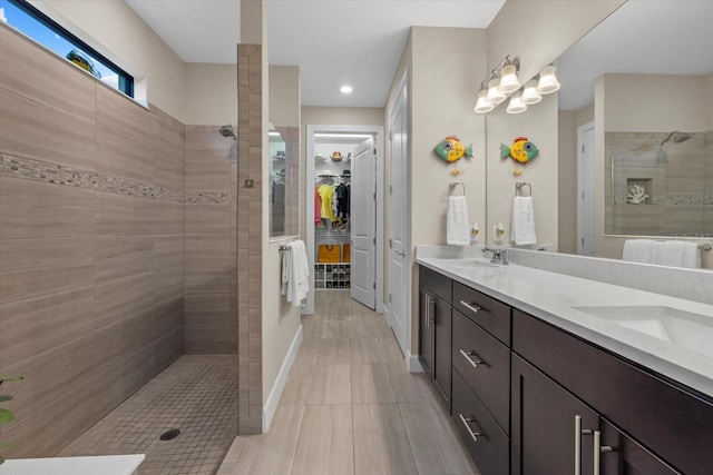 bathroom featuring tile patterned floors, vanity, and tiled shower